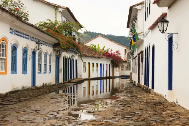 Casario colonial de Paraty refletido numa poça d’água no centro histórico