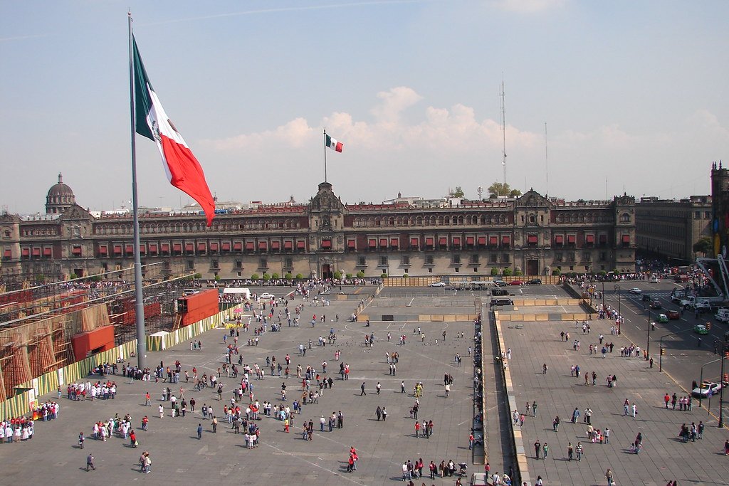 Vista aérea do Zócalo com a Catedral Metropolitana ao fundo e a bandeira gigante do México ao centro