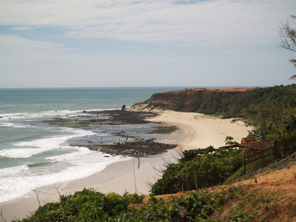 Vista aérea da Praia da Pipa com falésias alaranjadas, mar azul em Natal