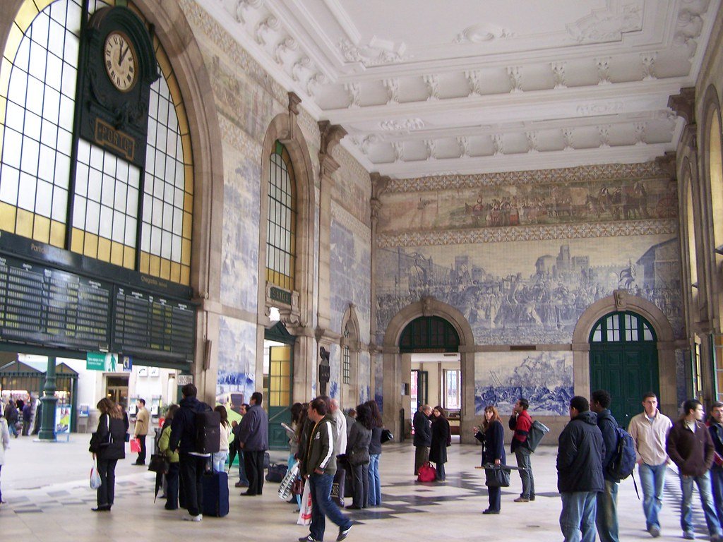 Interior da Estação São Bento coberta por azulejos azuis retratando cenas históricas de Portugal em Porto
