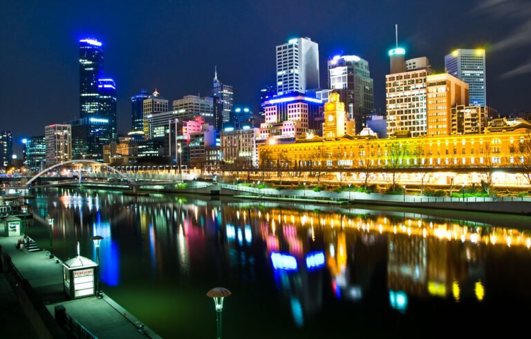 Melbourne Australia a noite com a cidade acesa com um corpo de água na frente