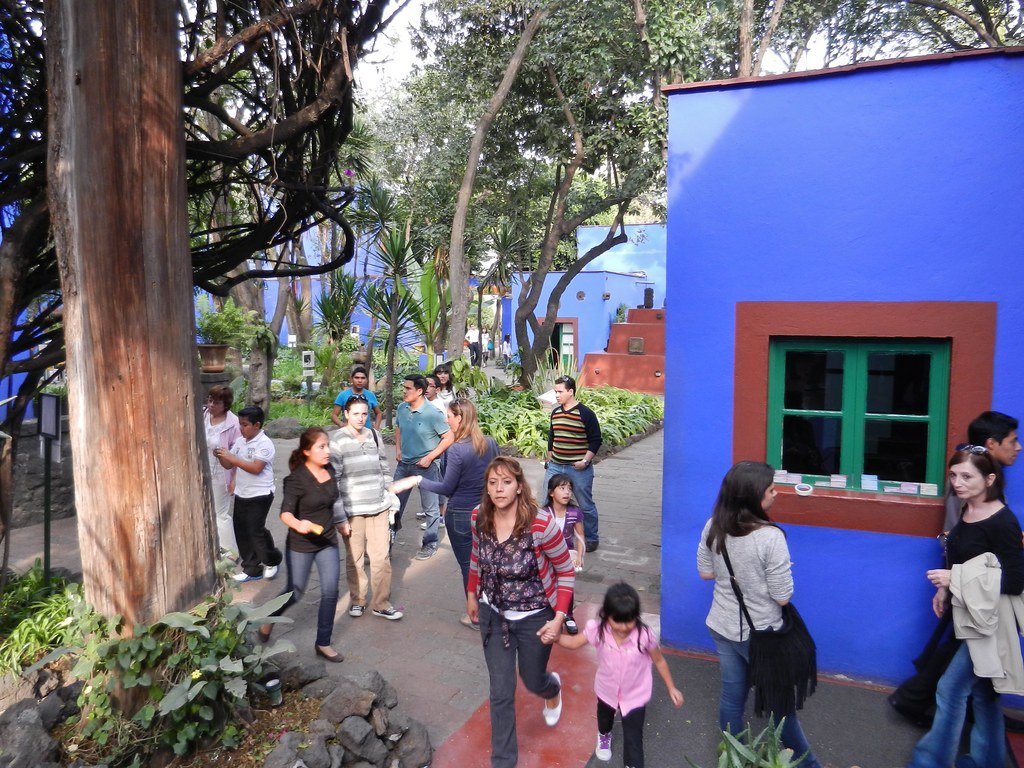 Entrada da Casa Azul de Frida Kahlo com paredes pintadas de azul vibrante e jardins internos na Cidade do México