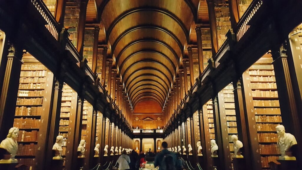 people inside library in the Long Room in Trinity College - Dublin