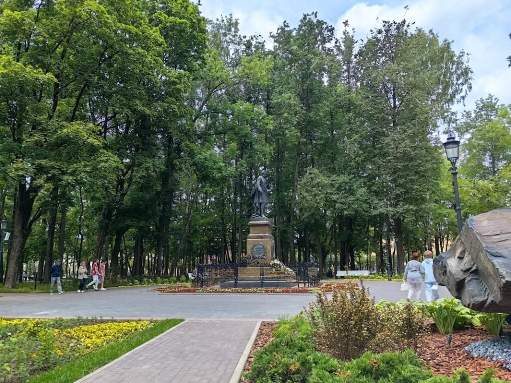 a statue in a park surrounded by trees in Parque Letná