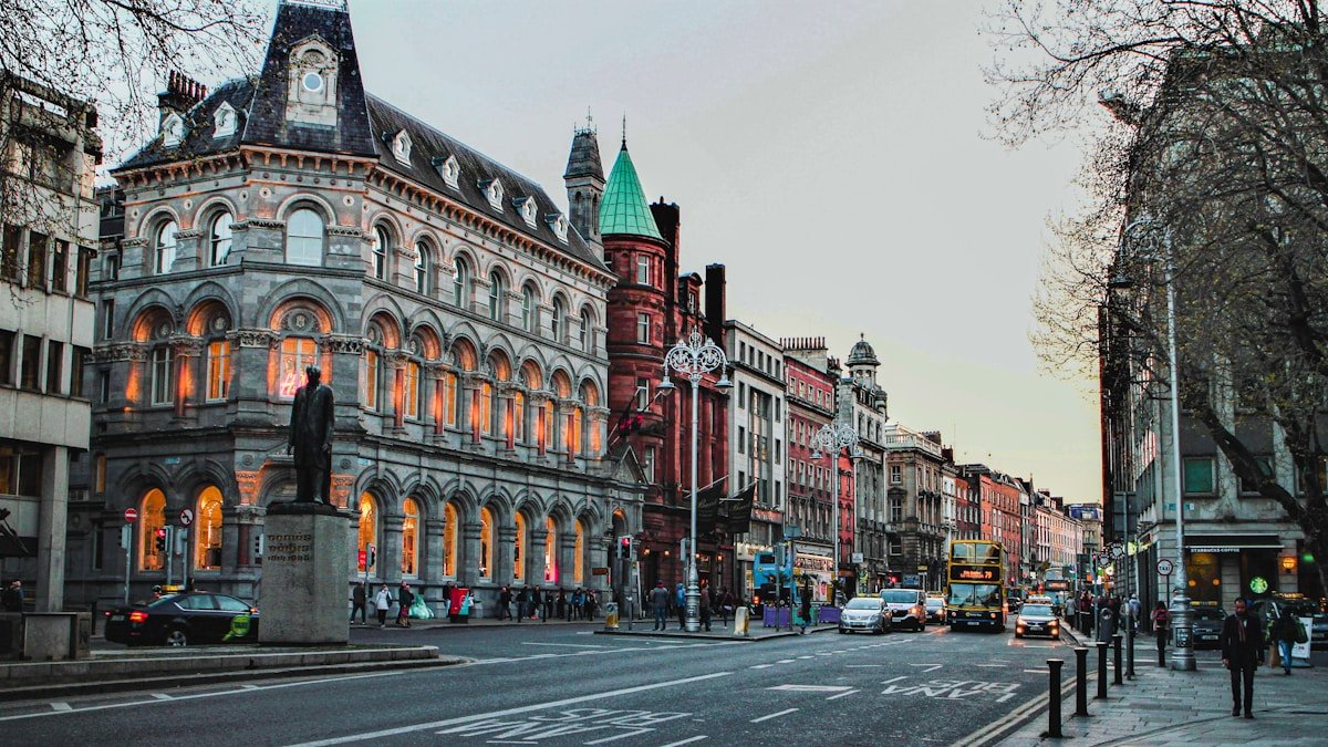 a city street with a clock tower in the middle of it in Dublin