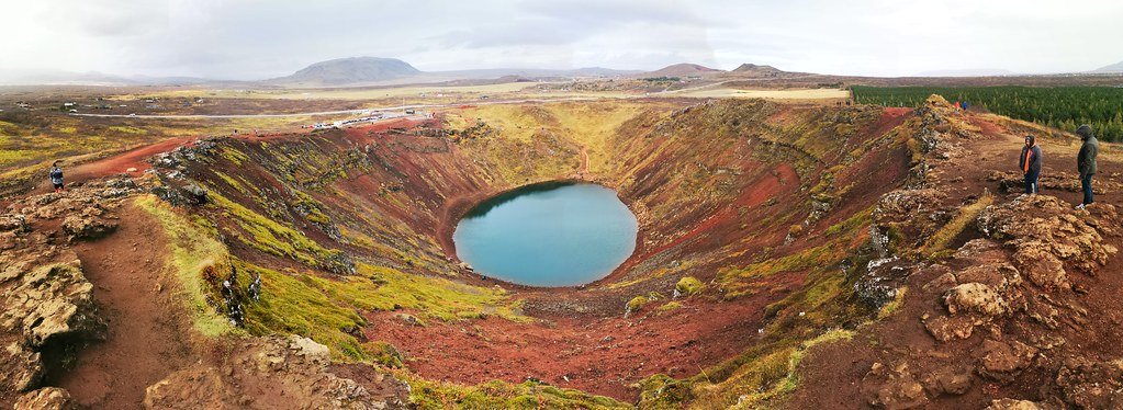 Vista aérea do Kerid Crater com suas margens vermelhas e lago azul turquesa ao centro