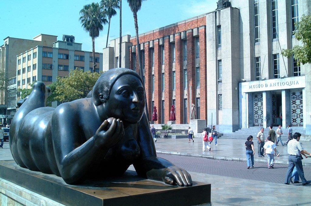 Plaza Botero com uma escultura de uma mulher e pessoas na rua em Medellin